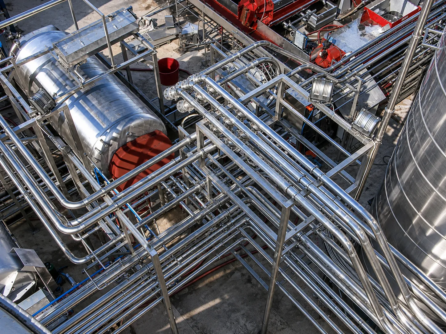 Struttura portante in acciaio inox con tubazioni per impianto enologico